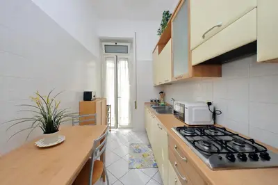 a kitchen with a stove top oven next to a counter at 4BNB - Cimabue Apartment in Rome