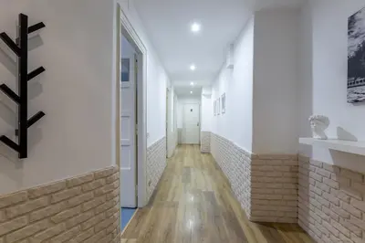 a hallway with white walls and a brick wall at Imperium House - appartamento con giardino privato, 3 minuti da Metro Piazza Bologna, A-C, in Rome
