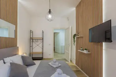 a bedroom with a bed and a tv on a wall at Imperium House - appartamento con giardino privato, 3 minuti da Metro Piazza Bologna, A-C, in Rome