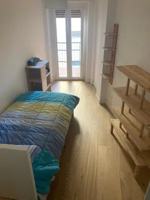 a bedroom with a bed and a wooden floor at Casa Caravella in Rome