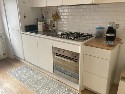 a white kitchen with a stove and a sink at Casa Caravella in Rome