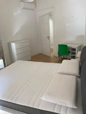 a bedroom with two beds and a green chair at Casa Caravella in Rome