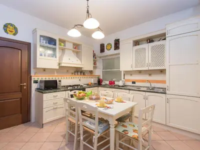 a kitchen with white cabinets and a table and chairs at Apartment Vaticanum Hills by Interhome in Rome