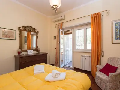 a bedroom with a yellow bed and a mirror and a chair at Apartment Vaticanum Hills by Interhome in Rome