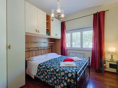a bedroom with a bed with a floral blanket at Apartment Vaticanum Hills by Interhome in Rome