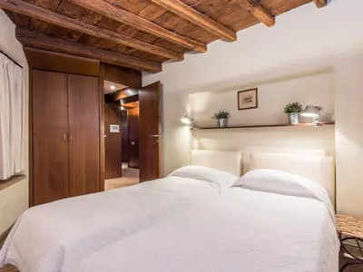 a bedroom with a large white bed with wooden ceilings at Apartment Augustus by Interhome in Rome
