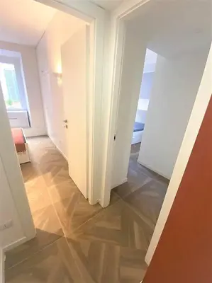 an empty room with a hallway with a door and a floor at La casa di Jonathan al Ghetto in Rome