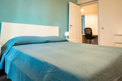 a bedroom with a large bed with a blue blanket at Limacino in Rome