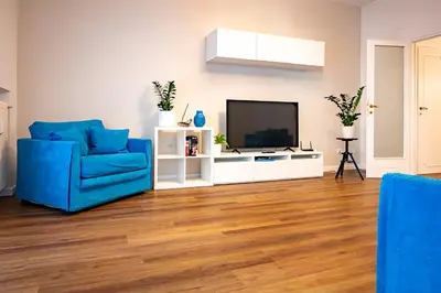 a living room with a blue chair and a television at Limacino in Rome