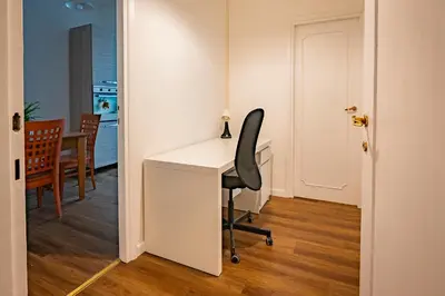 a white desk with a black chair in a room at Limacino in Rome