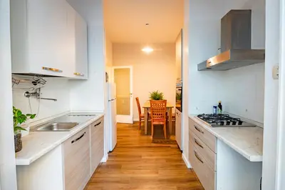 a kitchen with white cabinets and a sink and a table at Limacino in Rome
