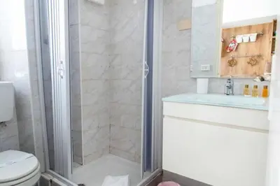 a kitchen with white cabinets and a white refrigerator at La casa di Marisela in Via Emanuele Filiberto in Rome