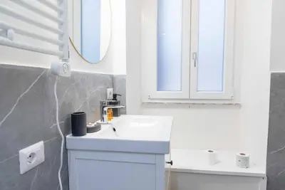 a bathroom with a white sink and a mirror at La casa di Jojo al Ghetto in Rome