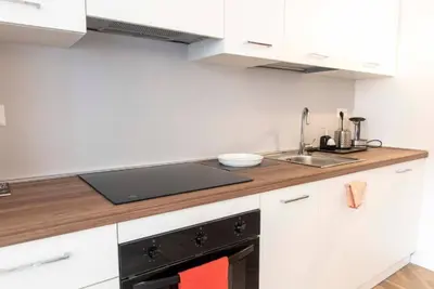 a kitchen with white cabinets and a black stove at La casa di Jojo al Ghetto in Rome