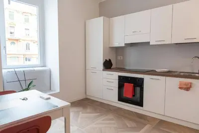 a kitchen with white cabinets and a stove top oven at La casa di Jojo al Ghetto in Rome