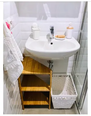 a bathroom with a white sink and a basket at A Casa di Lele in Rome