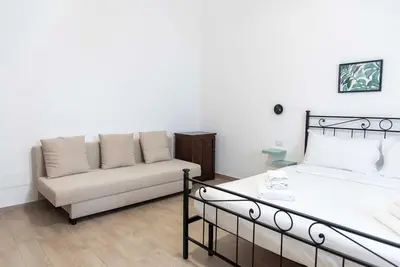 a living room with a bed and a couch at Domus Viola in San Giovanni in Rome