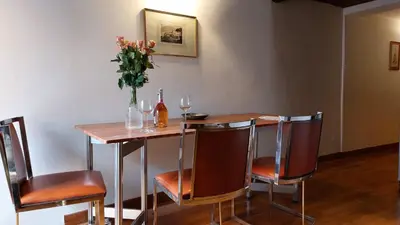 a table and chairs with a vase of flowers and wine glasses at Loft Colosseo, in Rome Center in Rome