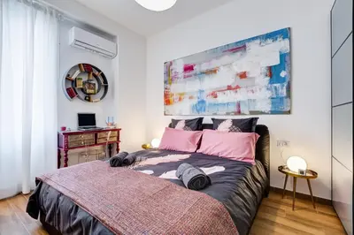 a bedroom with a large bed with pink pillows at Roma in relax lovely two room in the center of Rome, Fabrizia in Rome
