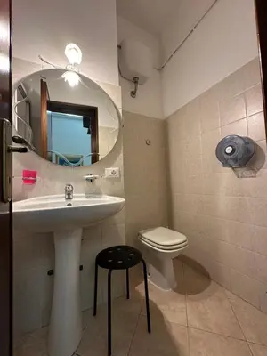 a bathroom with a sink and a toilet and a mirror at Alloggio Turistico in Rome