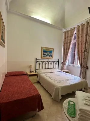a bedroom with two beds and a window at Alloggio Turistico in Rome