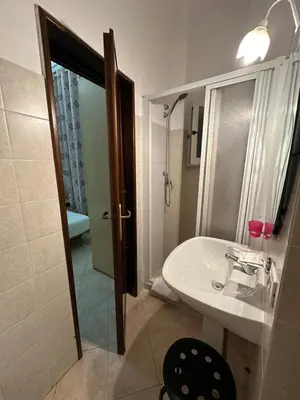 a bathroom with a sink and a shower and a mirror at Alloggio Turistico in Rome