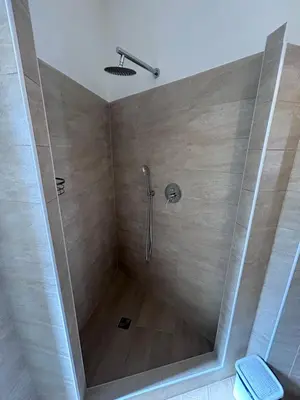a shower with a glass door in a bathroom at Ragusa Holiday Home in Rome