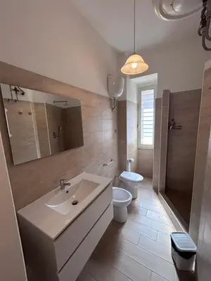 a bathroom with a sink and a toilet and a mirror at Ragusa Holiday Home in Rome