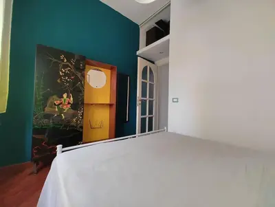 a bedroom with a large white bed in a room at La Casetta Azzurra in Rome