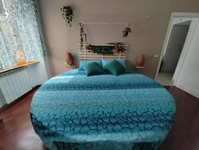a bedroom with a large bed with a blue comforter at La Casetta Azzurra in Rome
