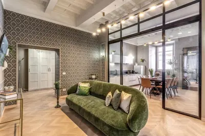 a living room with a green couch and a dining room at White Miracle Suite in Rome