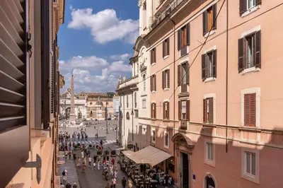 a group of people walking down a street between buildings at White Miracle Suite in Rome