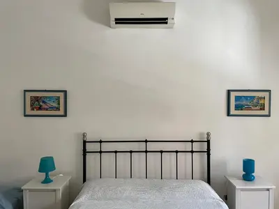 a bedroom with a bed and a air conditioner on the wall at Romolo House in Rome