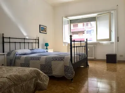 a bedroom with two beds and a window at Romolo House in Rome
