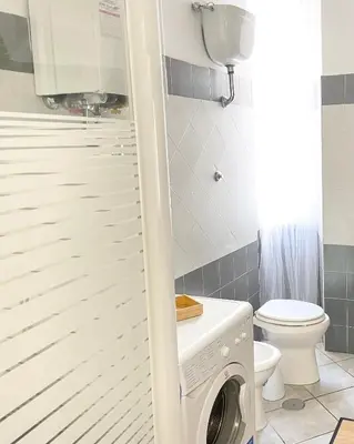 a small bathroom with a washer and dryer at Voluptas house Trastevere Testaccio in Rome