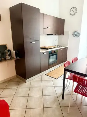 a kitchen with stainless steel appliances and a table at Voluptas house Trastevere Testaccio in Rome