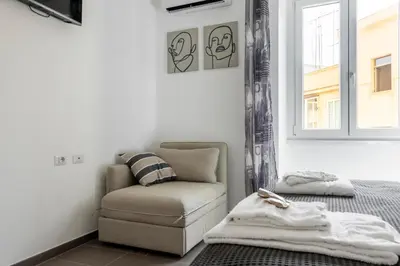 a bedroom with a couch and a chair and a window at Maison del Re - San Giovanni by RHR in Rome