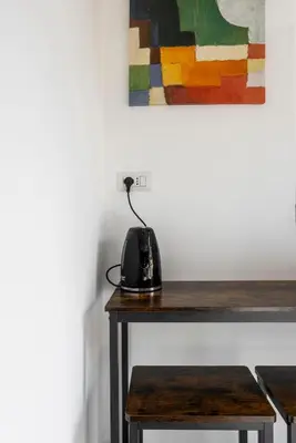a black telephone sitting on a wooden table with a painting at Maison del Re - San Giovanni by RHR in Rome