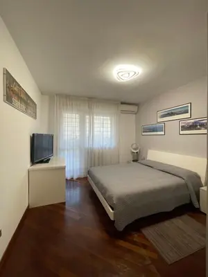 a bedroom with a bed and a flat screen tv at Stanza Eur Tintoretto in Rome