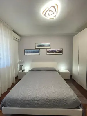 a bedroom with a bed and two night stands at Stanza Eur Tintoretto in Rome