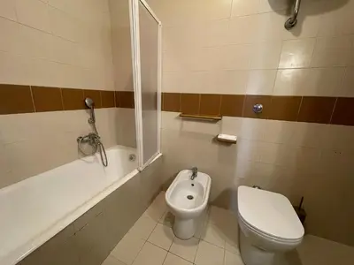 a bathroom with a toilet and a tub and a sink at Stanza Eur Tintoretto in Rome