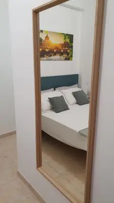 a mirror reflecting a bed in a room at Melory House in Rome