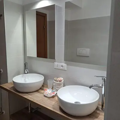 a bathroom with a large white sink and a mirror at Melory House in Rome