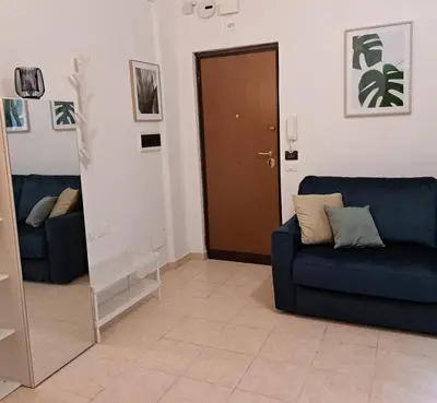 a living room with a blue couch and a mirror at Melory House in Rome