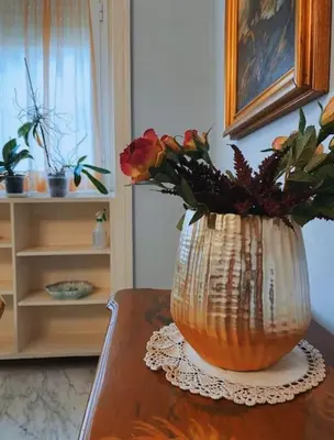 a vase with flowers in it sitting on a table at Joyful Home in Rome