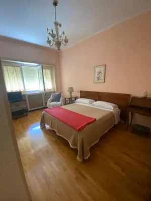 a bedroom with a large bed with a red blanket on it at Joyful Home in Rome