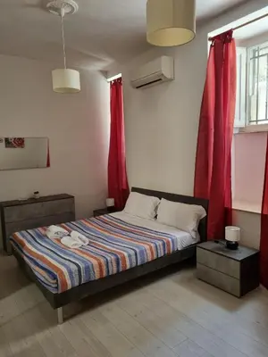 a bedroom with a bed with red drapes at Ad un passo dal Vaticano in Rome