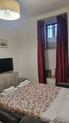 a bedroom with a bed with a colorful quilt on it at Ad un passo dal Vaticano in Rome