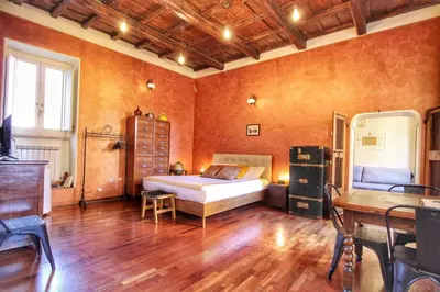 a bedroom with a bed and a desk in it at Trastevere Charming Romantic Loft By YourHost in Rome
