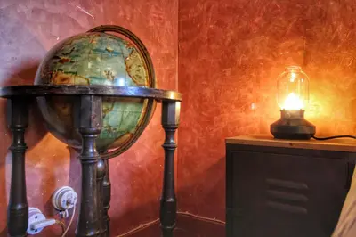 a globe on a table next to a lamp at Trastevere Charming Romantic Loft By YourHost in Rome